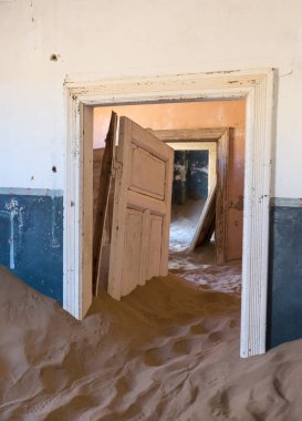 Terk edilmiş ve unutulmuş bina ve oda insanlar tarafından terk edilmiş ve işgal edilen kum fırtınası, Kolmanskop hayalet kasabası, Namib Çölü tarafından ele geçirilmiş.