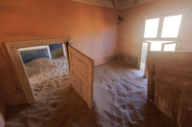Terk edilmiş ve unutulmuş bina ve oda insanlar tarafından terk edilmiş ve işgal edilen kum fırtınası, Kolmanskop hayalet kasabası, Namib Çölü tarafından ele geçirilmiş.