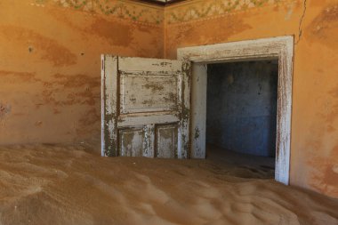 Terk edilmiş ve unutulmuş bina ve oda insanlar tarafından terk edilmiş ve işgal edilen kum fırtınası, Kolmanskop hayalet kasabası, Namib Çölü tarafından ele geçirilmiş.