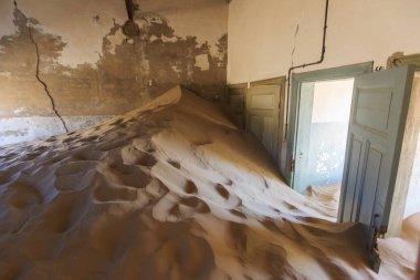 Terk edilmiş ve unutulmuş bina ve oda insanlar tarafından terk edilmiş ve işgal edilen kum fırtınası, Kolmanskop hayalet kasabası, Namib Çölü tarafından ele geçirilmiş.