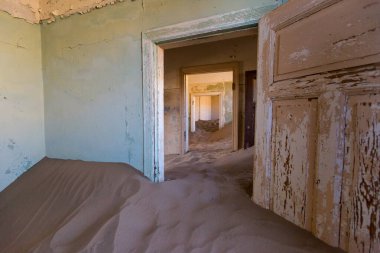 Terk edilmiş ve unutulmuş bina ve oda insanlar tarafından terk edilmiş ve işgal edilen kum fırtınası, Kolmanskop hayalet kasabası, Namib Çölü tarafından ele geçirilmiş.