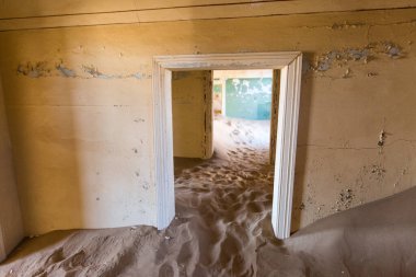 Terk edilmiş ve unutulmuş bina ve oda insanlar tarafından terk edilmiş ve işgal edilen kum fırtınası, Kolmanskop hayalet kasabası, Namib Çölü tarafından ele geçirilmiş.
