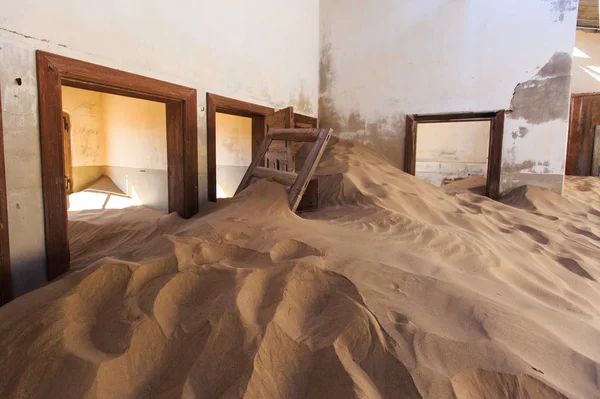 Edificio abbandonato e dimenticato e stanza lasciata dalla gente e presa in consegna da una tempesta di sabbia, città fantasma di Kolmanskop, Namib Desert — Foto Stock