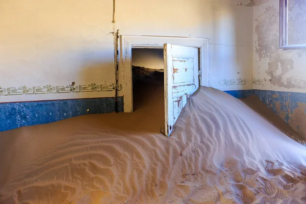 Terk edilmiş ve unutulmuş bina ve oda insanlar tarafından terk edilmiş ve işgal edilen kum fırtınası, Kolmanskop hayalet kasabası, Namib Çölü tarafından ele geçirilmiş.