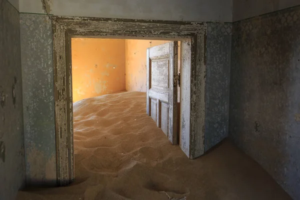 Terk edilmiş ve unutulmuş bina ve oda insanlar tarafından terk edilmiş ve işgal edilen kum fırtınası, Kolmanskop hayalet kasabası, Namib Çölü tarafından ele geçirilmiş.