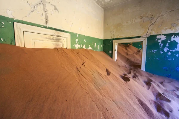 Terk edilmiş ve unutulmuş bina ve oda insanlar tarafından terk edilmiş ve işgal edilen kum fırtınası, Kolmanskop hayalet kasabası, Namib Çölü tarafından ele geçirilmiş.