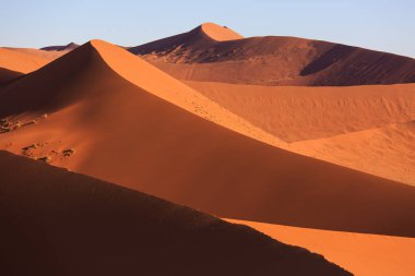 Çölde gün batımında kırmızı kum tepeleri olan güzel bir manzara. Sossusvlei, Namib Naukluft Ulusal Parkı, Namibya. İnsansız şaşırtıcı doğal geometri