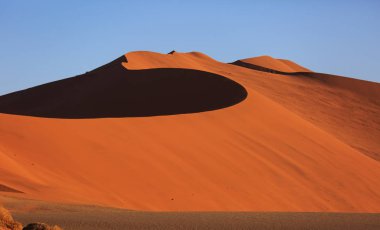Çölde gün batımında kırmızı kum tepeleri olan güzel bir manzara. Sossusvlei, Namib Naukluft Ulusal Parkı, Namibya. İnsansız şaşırtıcı doğal geometri
