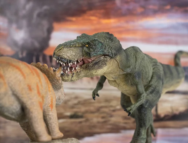 Tyrannosaurus rex lutando com um tricerátopo com vulcão em erupção no fundo . — Fotografia de Stock