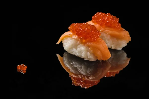 Sushi y caviar rojo sobre acrílico negro —  Fotos de Stock