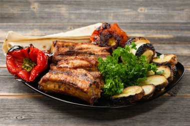 Rustik tarzda Yeşiller siyah plakalı bir ızgara et ve sebze kavrulmuş