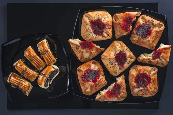 Gâteaux de pavot et de confiture d'une forme différente sur de petites et grandes assiettes carrées en céramique — Photo