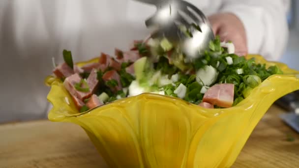 De kok mengt groenten en de ham salade in mooi aardewerk — Stockvideo