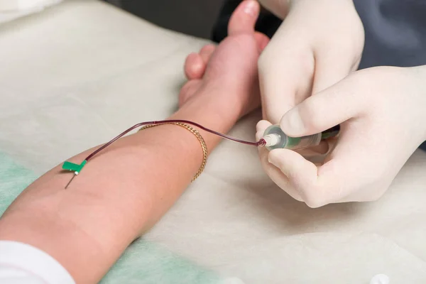 Mãos em látex luvas médicas fazer punção venosa na área de dobra ulnar da mão do paciente — Fotografia de Stock