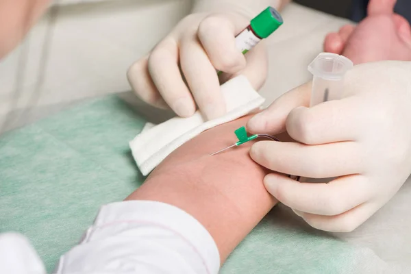 Mãos em látex luvas médicas fazer punção venosa na curva ulnar da mão do paciente — Fotografia de Stock