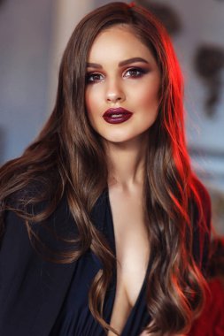 Stüdyoda poz veren güzel genç bir kadın.