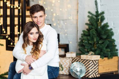 Genç çift köknar ile merdivenlerde oturan poz reklam çelenk ışıklar ağaçlar