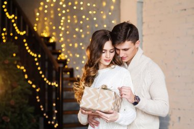 Noel hediye kutusu tutan genç çift sarılma 