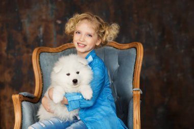 rahat Oda kol sandalyede oturan beyaz tüylü köpek ile poz sarışın kız
