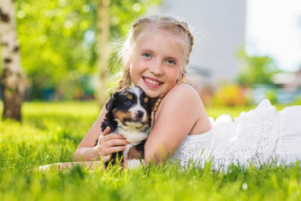 Little Blonde Girl Playing Cute Black Puppy Sitting Green Grass — Stock Photo, Image