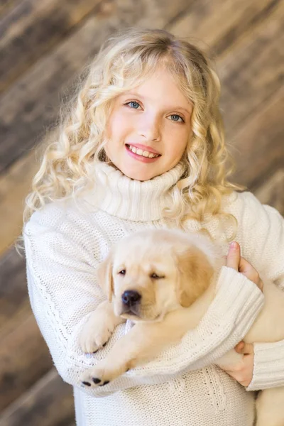 ラブラドールを持ってポーズをとって白いウールのセーターでかわいい女の子の子犬 — ストック写真