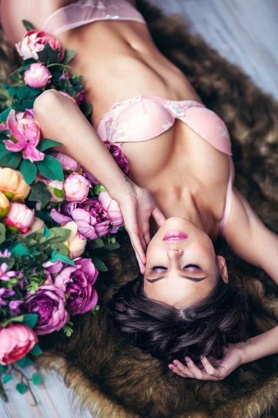 Jonge Brunette Vrouw Poseren Lingerie Liggend Bont Met Kleur Bloemen — Stockfoto