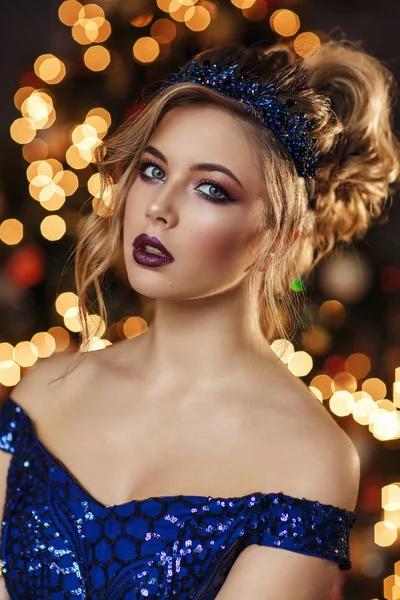 スパンコールぼやけのクリスマス ツリー前にピンクのギフト ボックスとポーズと濃い青のドレスで美しい少女の肖像画 — ストック写真