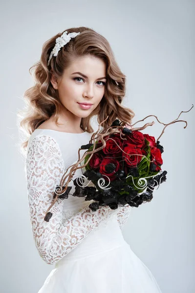 白い結婚式で若い美しい女性のファッションの肖像画のドレス赤いバラの花束でポーズ — ストック写真