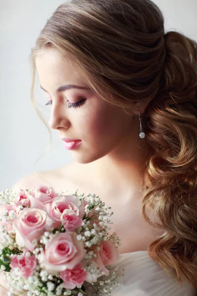 年轻美丽的女人在白色的婚纱礼服摆在粉红色玫瑰花束的时尚肖像 — 图库照片