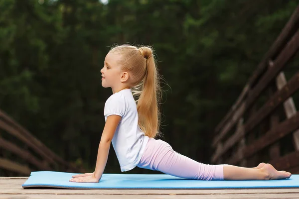 Little girl doing fitness outdoor