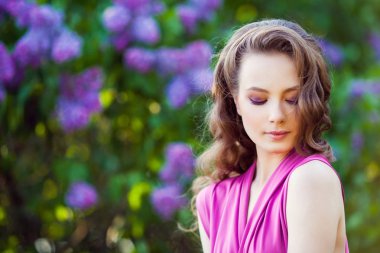 Leylak çiçeği çalıların yakınındaki poz genç güzel kız