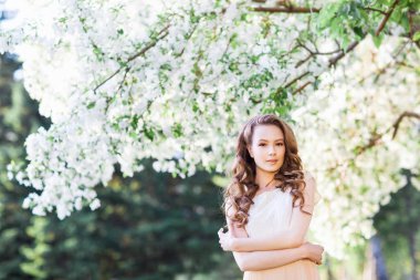 Elma-ağacı çiçeği yakınındaki poz genç güzel kadın