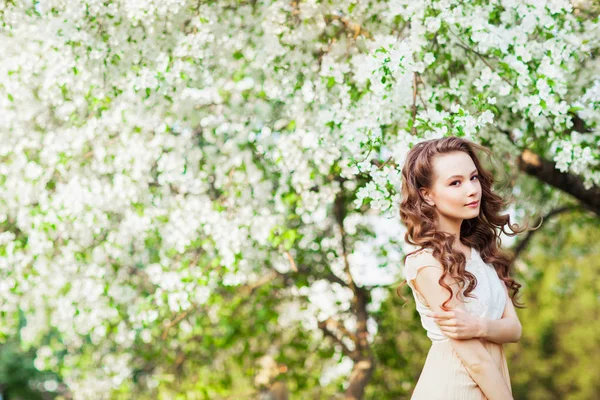 年轻美丽的妇女摆在苹果树在开花 — 图库照片