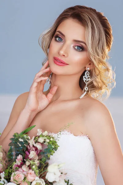 年轻美丽的女人在白色婚纱礼服摆着花束的时尚肖像 — 图库照片