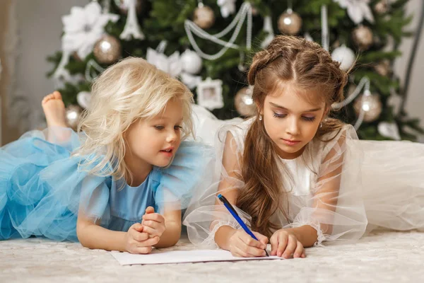 Two attractive girls writing letter to Santa Claus