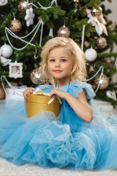 小金发女孩与礼物在圣诞树附近 — 图库照片