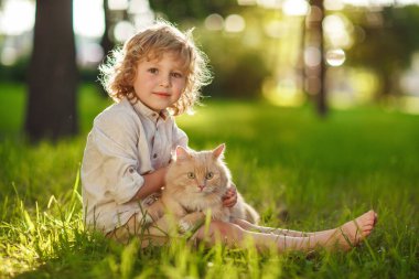 Kızıl kedili kıvırcık çocuk.