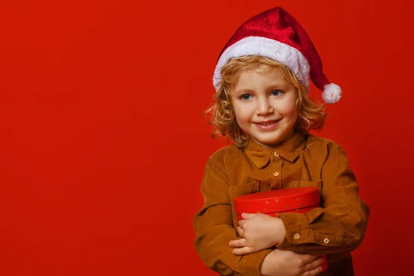 Little Curly Boy Gift Red Background — Stock Photo, Image