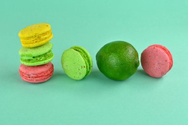 Turkuaz arka planda makarna. Renkli arka planda çok renkli badem kurabiyeleri. Tatlı olarak turkuaz arka planda çok renkli kurabiyeler. Limon ve badem kurabiyesi..