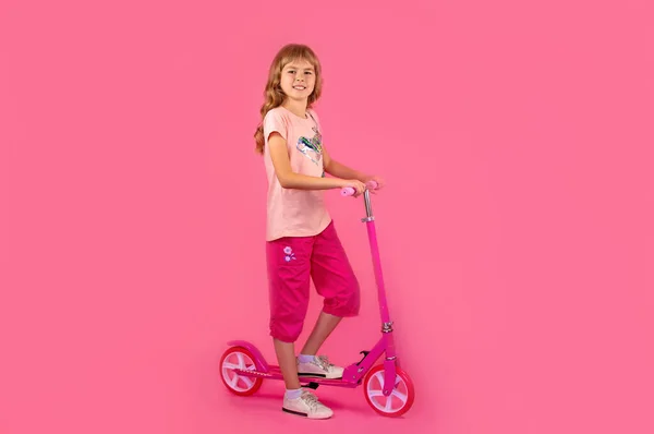 Klein Meisje Met Een Roze Scooter Een Roze Achtergrond Mooi — Stockfoto