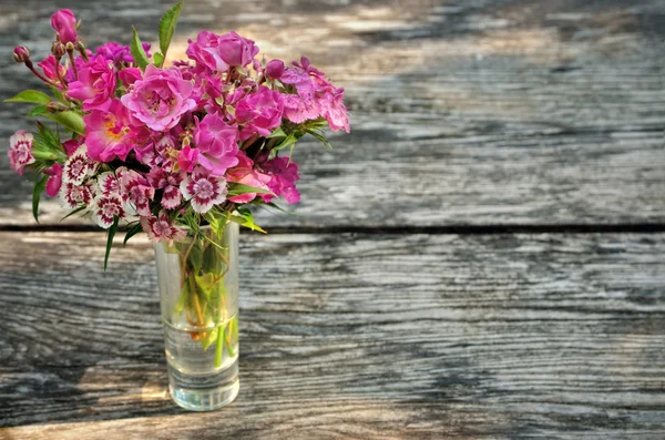 Bouquet of small carnations on a table in the garden — Stock Photo, Image