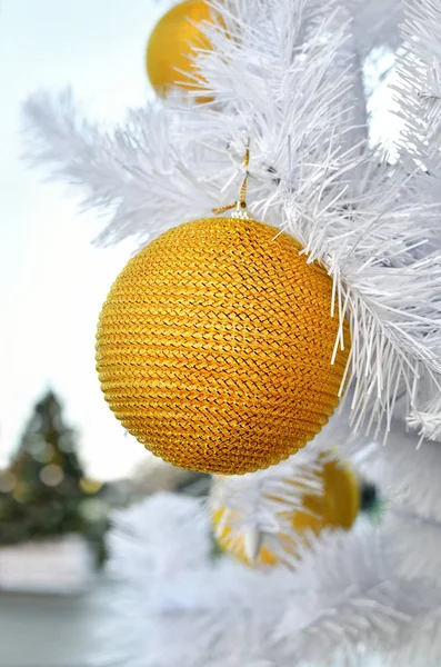 Gele Christmas speelgoed op een witte pluizige boom. — Stockfoto