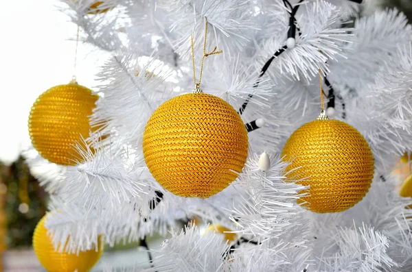 Gelbes Weihnachtsspielzeug auf einem weißen, flauschigen Baum. — Stockfoto