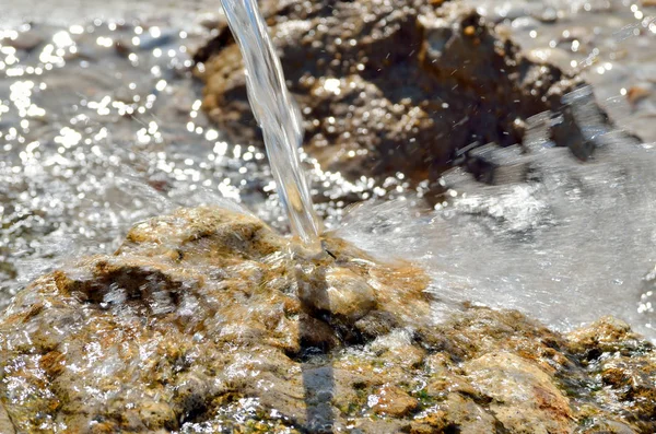 Strumień czystej czystej wody przelewa się na kamieniach. — Zdjęcie stockowe