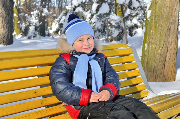 Menino caminhando no parque coberto de neve no inverno — Fotografia de Stock