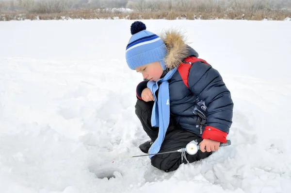 Menino pescando no rio congelado no inverno — Fotografia de Stock