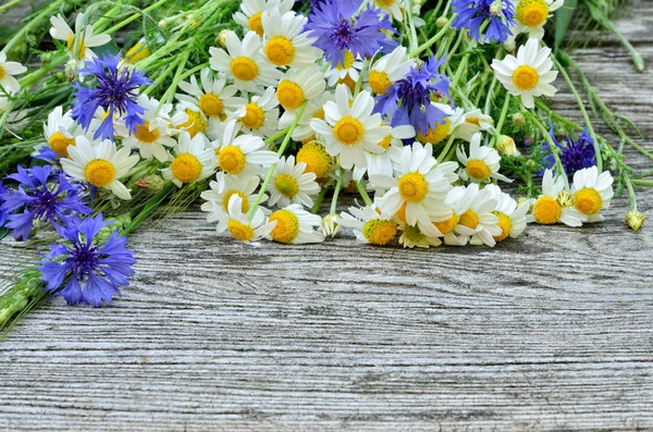 A bouquet of daisies and cornflowers on wooden table. Postcard of wild flowers — Stock Photo, Image