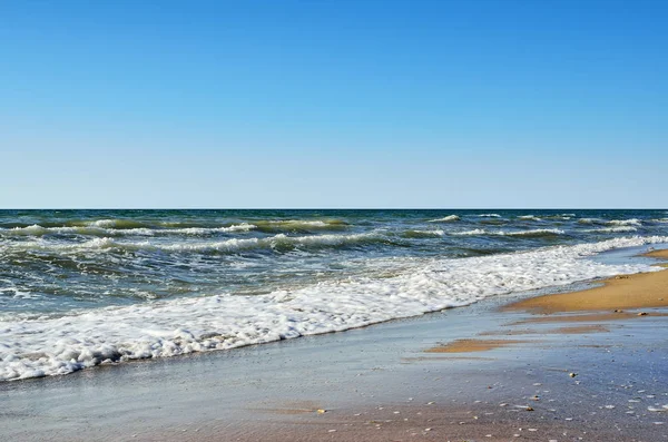 海浪冲刷着沙滩蓝天的衬托 — 图库照片