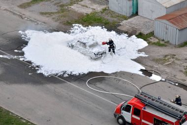 İtfaiyeciler tarafından bir köpük araba yakma söndürülür. Özel kurtarma hizmetleri çalışmalarını