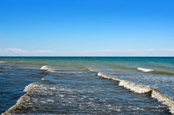 Las olas del mar lavaron la playa limpia hecha de conchas. Paisaje en una playa salvaje. El mar en el verano — Foto de Stock